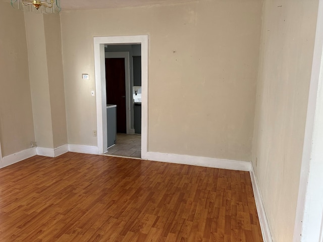 unfurnished room featuring a chandelier and light hardwood / wood-style flooring