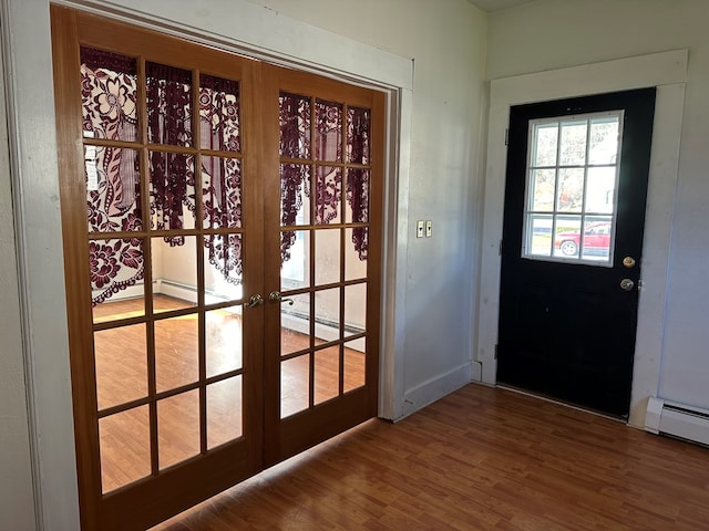 doorway to outside featuring french doors, baseboard heating, and hardwood / wood-style floors