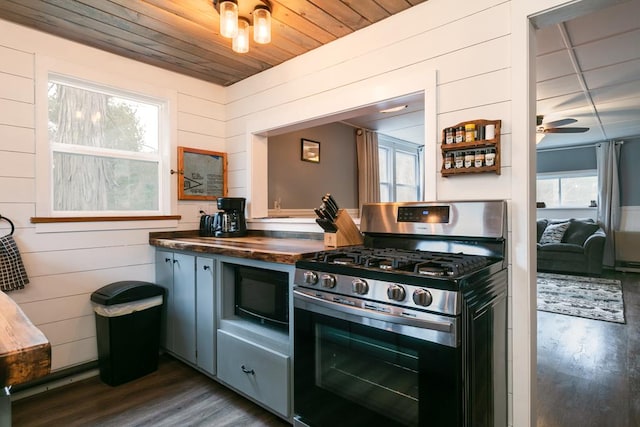 77 Pine Creek Village Rd, Gaines, PA 16921 - kitchen with wood walls, dark wood-style flooring, stainless steel gas stove, black microwave, and a wealth of natural light