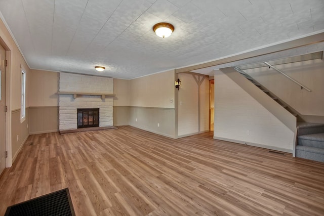 unfurnished living room featuring wood-type flooring, a textured ceiling, and a fireplace