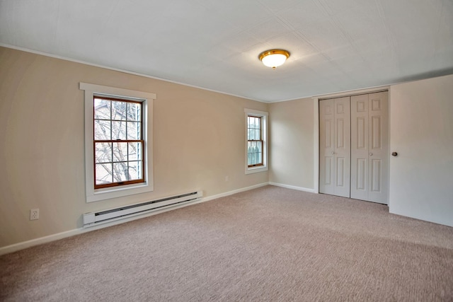 unfurnished bedroom with baseboard heating, carpet flooring, and a closet