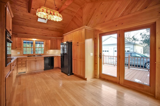 kitchen featuring decorative light fixtures, sink, black appliances, and light hardwood / wood-style floors