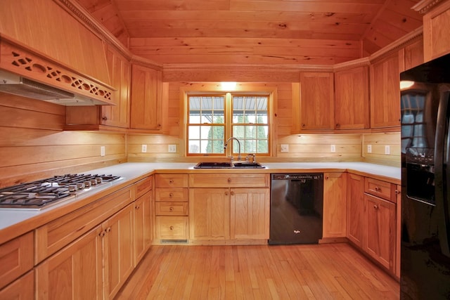 kitchen with custom range hood, black appliances, lofted ceiling, sink, and light wood-type flooring