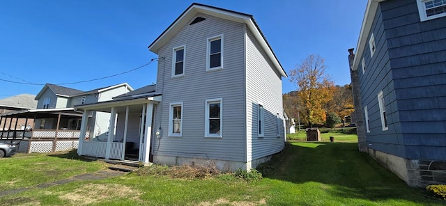 back of house with a lawn and a porch