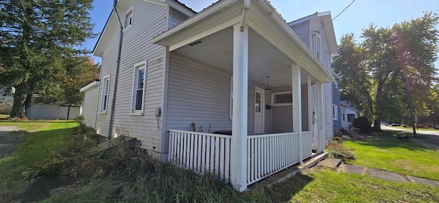 view of side of property with a porch and a yard