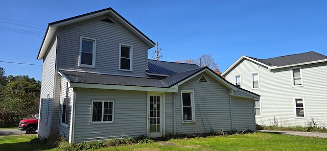 rear view of property with a lawn