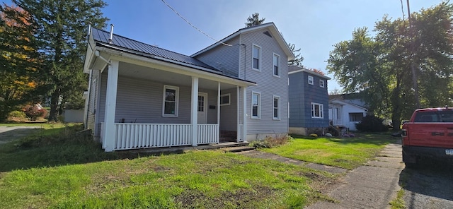 view of front of property with a front lawn, covered porch, and solar panels