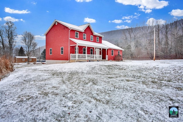 snow covered rear of property with a porch