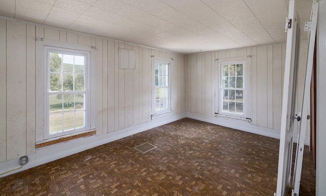 unfurnished room with dark parquet flooring and plenty of natural light