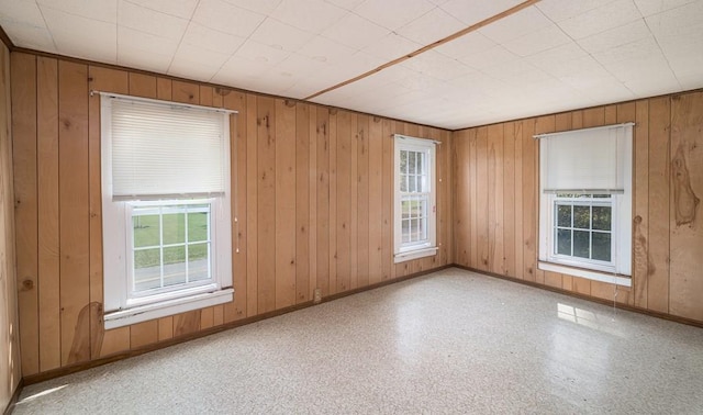 spare room with wood walls