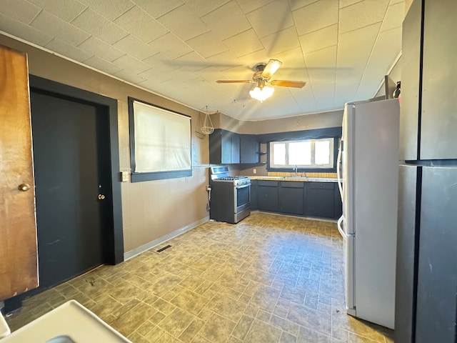 kitchen with gas range, white refrigerator, ceiling fan, and sink