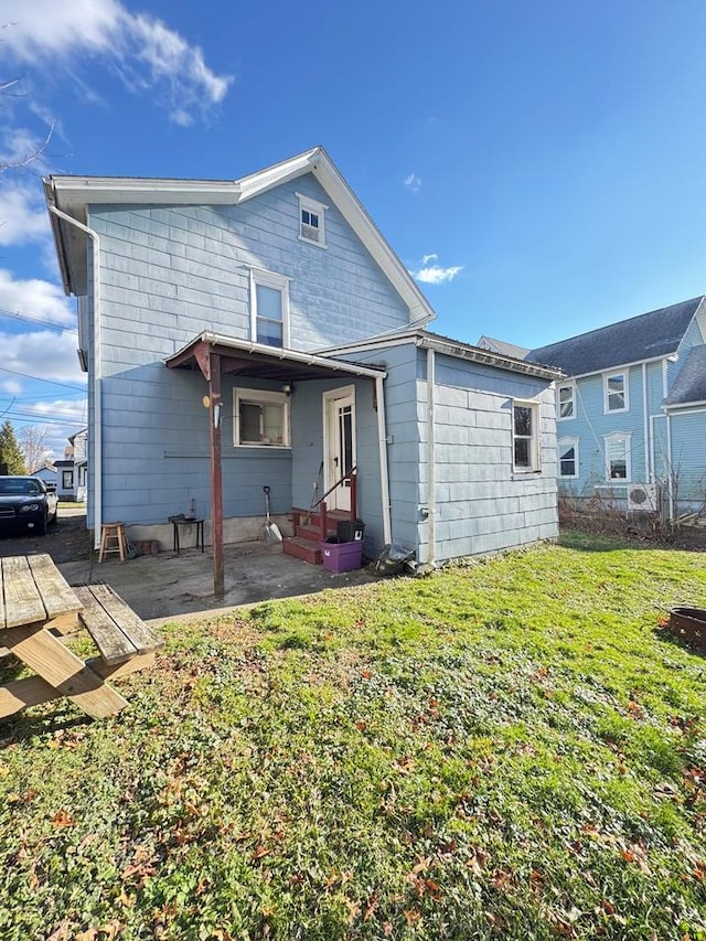 back of house with a lawn and a patio area