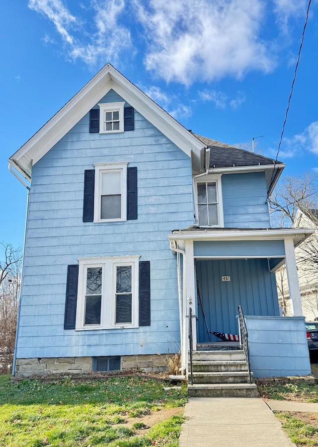 view of front of house with a porch and a front lawn