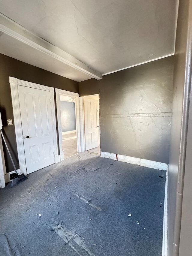 unfurnished bedroom featuring beam ceiling