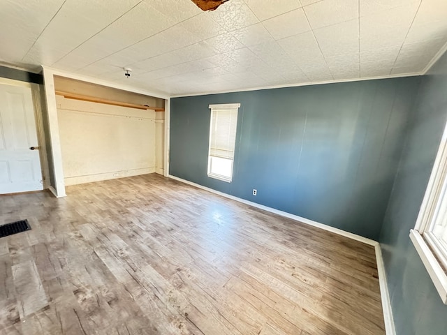 unfurnished bedroom featuring hardwood / wood-style flooring, a closet, and ornamental molding