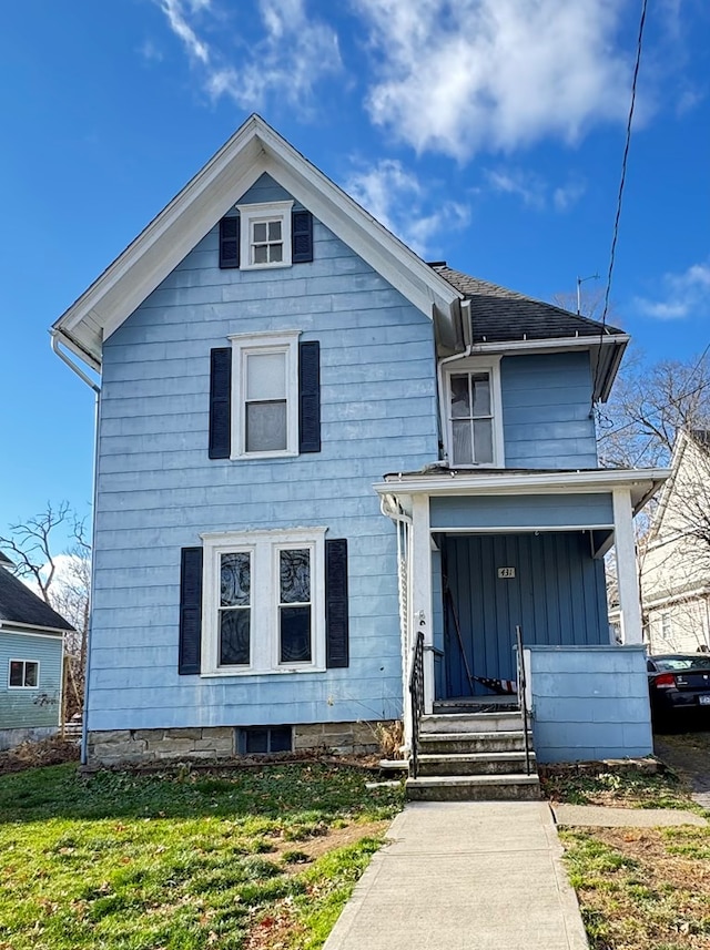 view of front of property featuring covered porch and a front yard