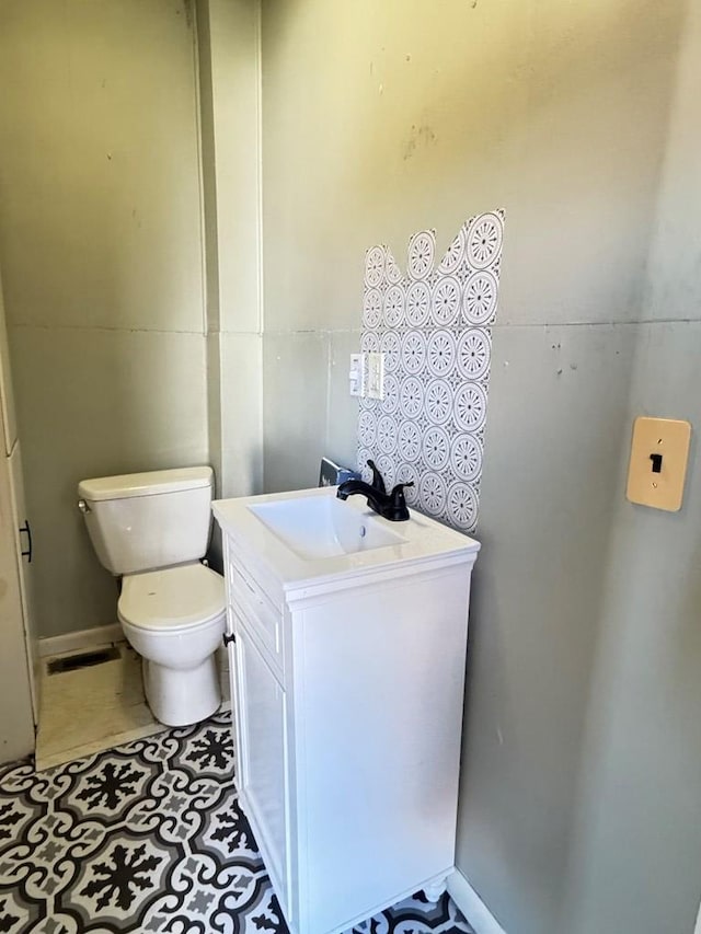 bathroom featuring tile patterned flooring, vanity, and toilet