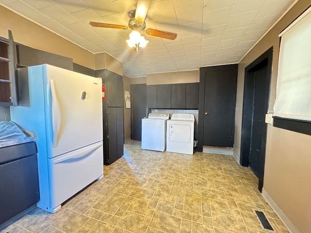 kitchen featuring separate washer and dryer, ceiling fan, and white fridge