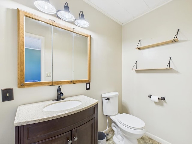 bathroom featuring vanity, toilet, and baseboards