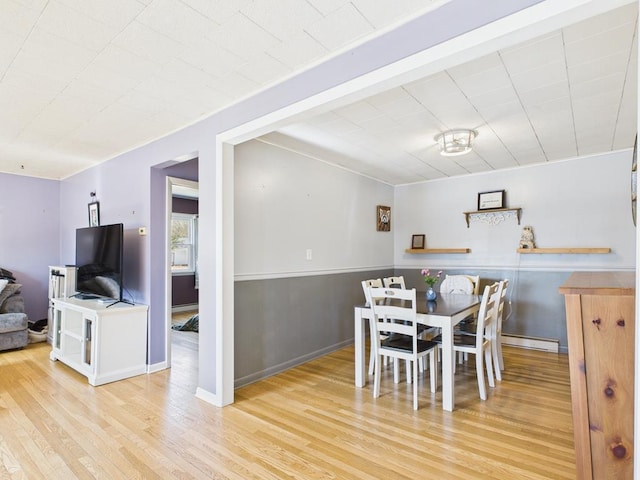 dining room with a baseboard radiator and wood finished floors