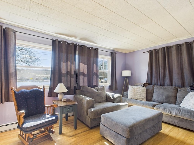 living room with baseboard heating and wood finished floors