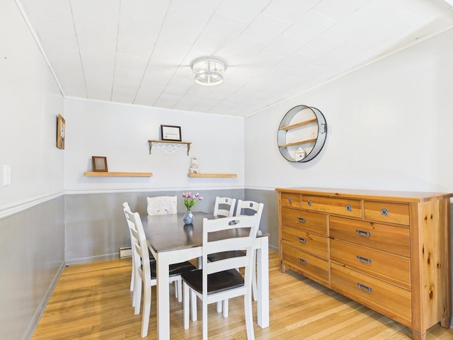 dining room with ornamental molding and light wood finished floors