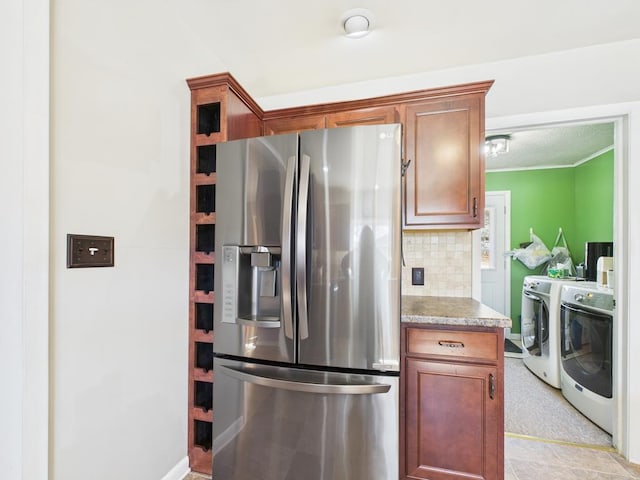 kitchen with independent washer and dryer, stainless steel refrigerator with ice dispenser, a textured ceiling, tasteful backsplash, and crown molding