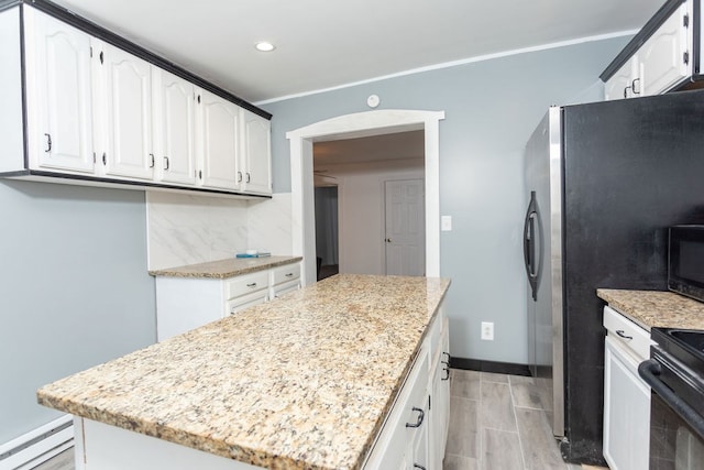 kitchen with decorative backsplash, light stone counters, baseboard heating, white cabinets, and a kitchen island