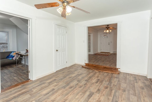 spare room with hardwood / wood-style floors, a baseboard radiator, and ceiling fan