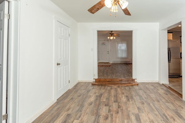 interior space featuring hardwood / wood-style floors, ceiling fan, and baseboard heating