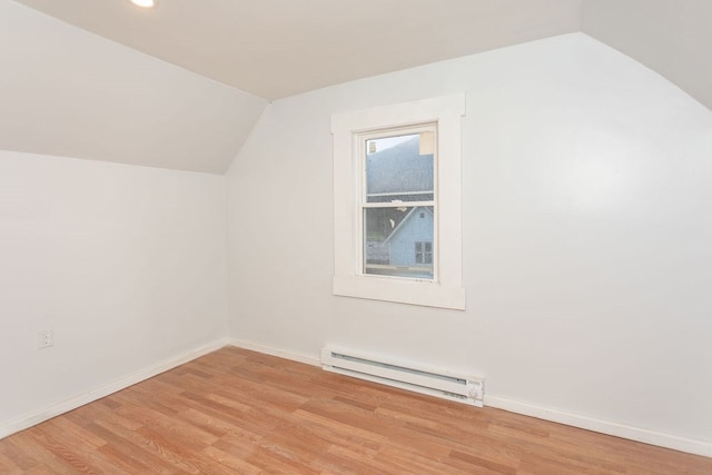 additional living space featuring light hardwood / wood-style floors, lofted ceiling, and a baseboard heating unit