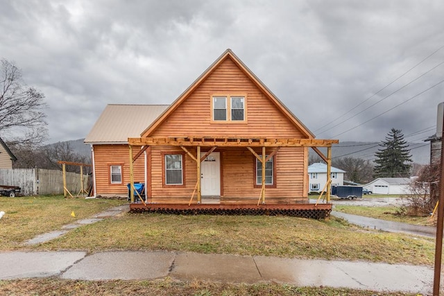 cabin with covered porch and a front yard