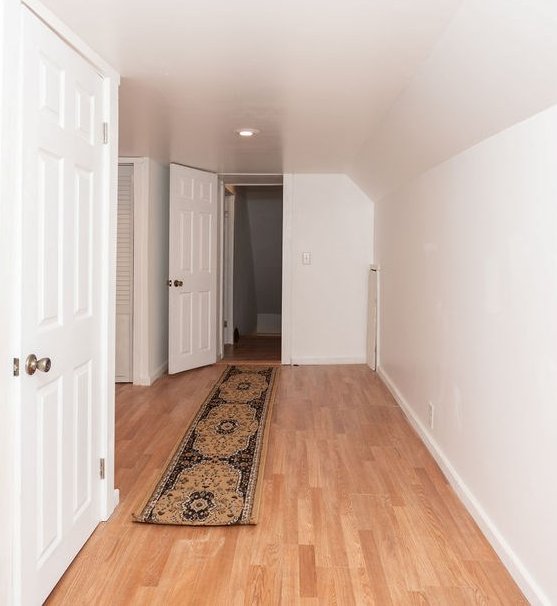 corridor featuring light hardwood / wood-style floors and vaulted ceiling