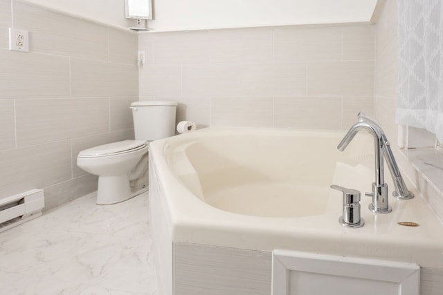 bathroom featuring a bath, baseboard heating, toilet, and tile walls