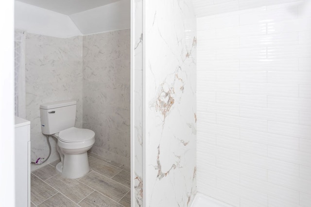 bathroom with tile walls and toilet