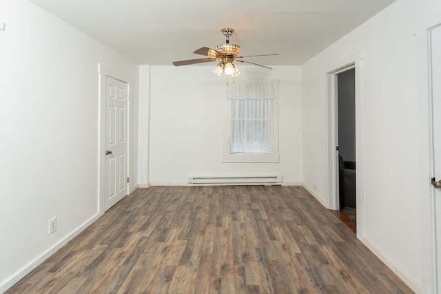 spare room with dark hardwood / wood-style flooring, baseboard heating, and ceiling fan