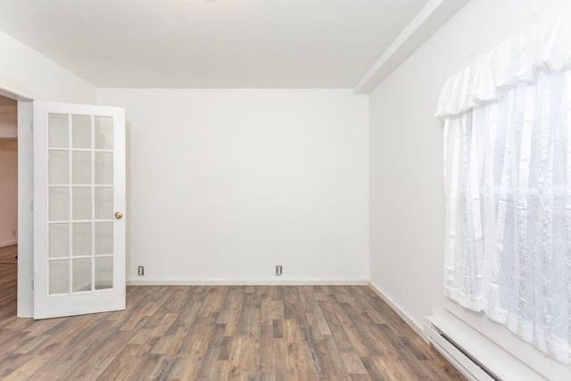 spare room featuring french doors, a baseboard radiator, and dark hardwood / wood-style floors