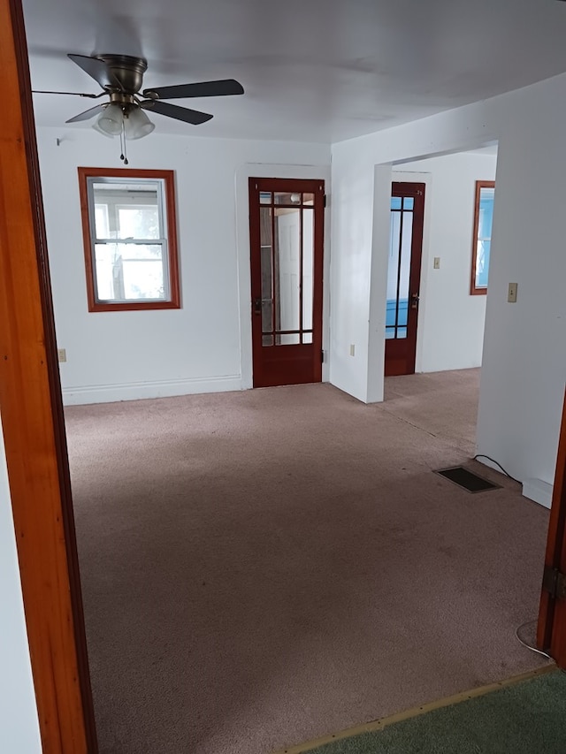 carpeted spare room featuring ceiling fan