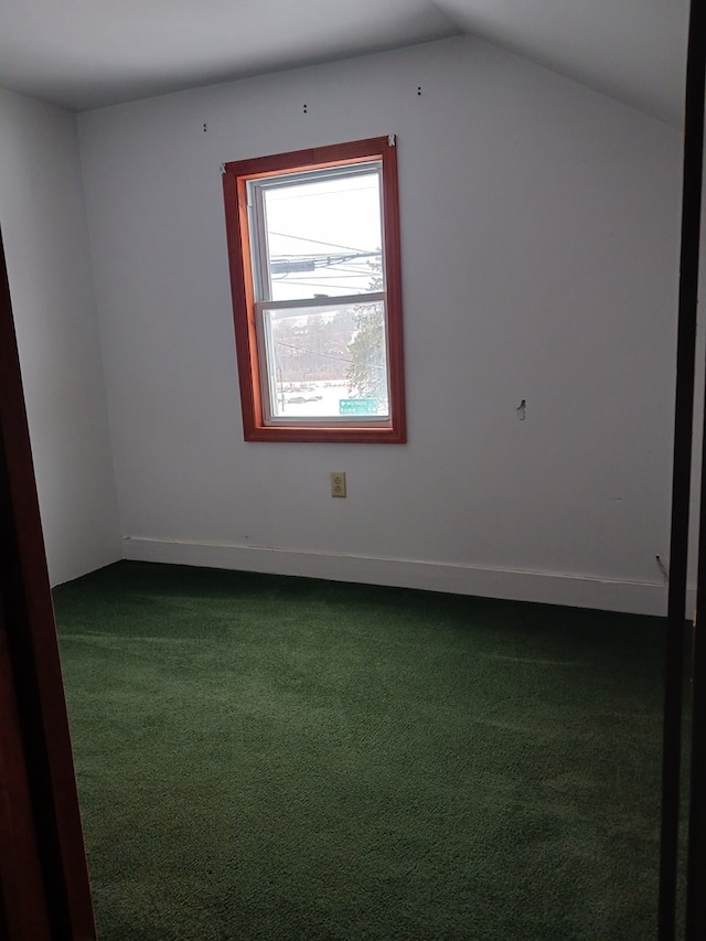 additional living space featuring lofted ceiling and dark carpet