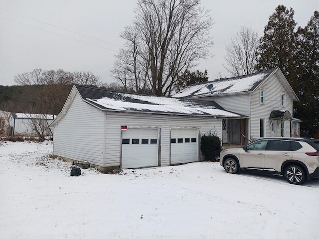 view of snow covered exterior featuring a garage