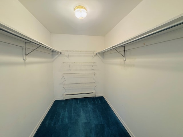 spacious closet with baseboard heating and dark carpet