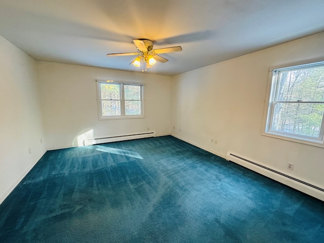 carpeted spare room with ceiling fan and a baseboard heating unit