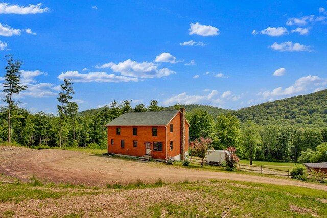 5284-A Rte 6 W, Ulysses, PA 16948 - view of side of home with a wooded view, curved driveway, a chimney, and entry steps