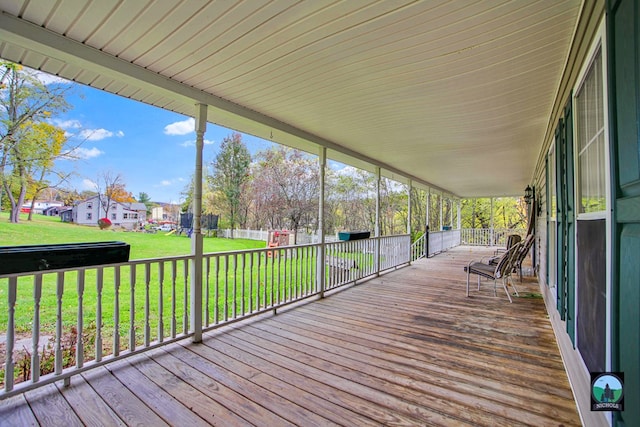 wooden deck featuring a lawn