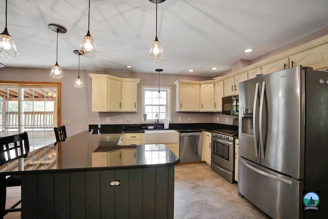 kitchen with a kitchen breakfast bar, sink, stainless steel appliances, and decorative light fixtures