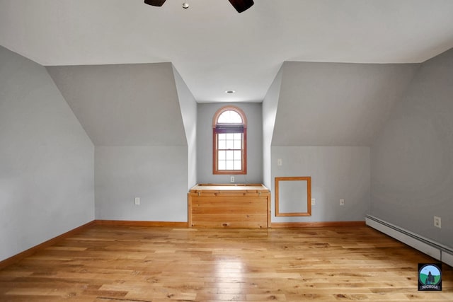 bonus room featuring light hardwood / wood-style floors, vaulted ceiling, baseboard heating, and ceiling fan