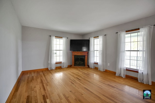 unfurnished living room with a healthy amount of sunlight and light hardwood / wood-style floors