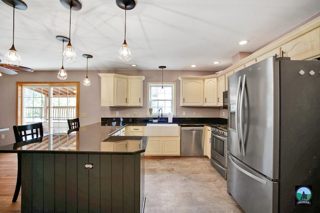 kitchen with appliances with stainless steel finishes, decorative light fixtures, plenty of natural light, and sink