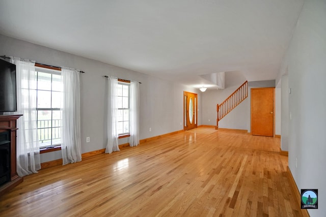 unfurnished living room featuring a wealth of natural light and light hardwood / wood-style flooring