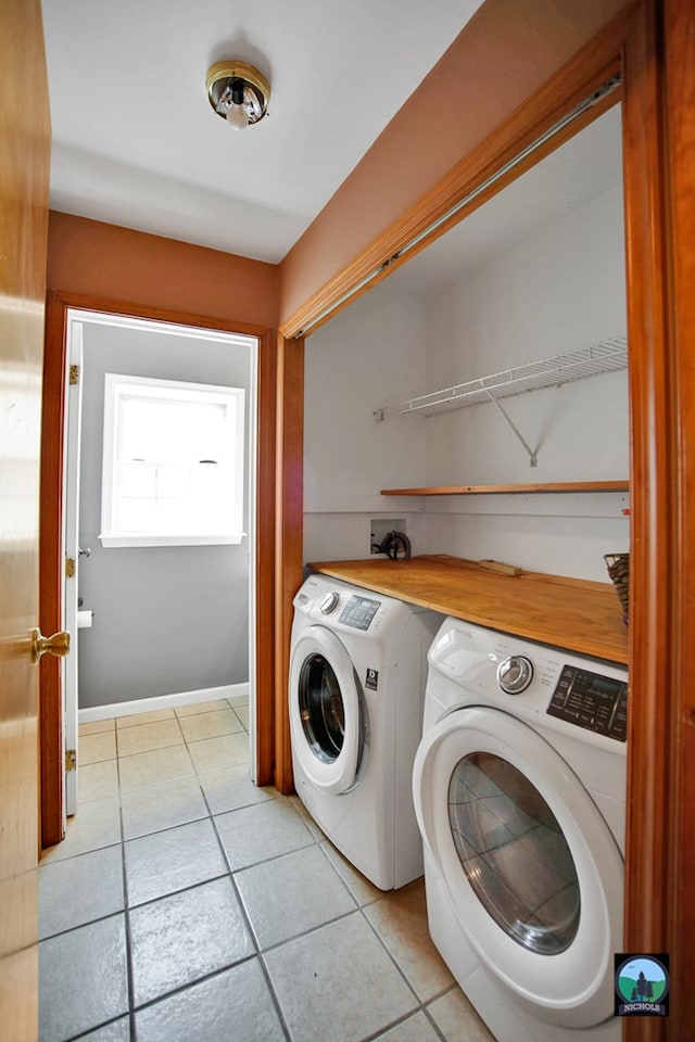 laundry area with washing machine and dryer and light tile patterned flooring